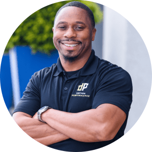 Smiling person in a black Driven Performance polo shirt, arms crossed.